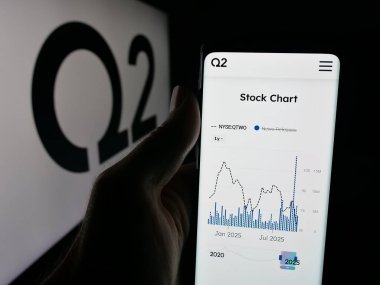Stuttgart, Almanya - 10-10-2025: ABD 'li bankacılık çözümleri şirketi Q2 Holding Inc.' in web sayfasını elinde tutan kişi logonun önünde ekranda. Telefon ekranının merkezine odaklan.