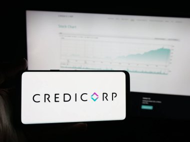 Stuttgart, Almanya - 10-11-2025: Perulu finans şirketi Credicorp 'un logosunu elinde tutan kişi web sitesinin önünde ekranda. Telefon ekranına odaklan.