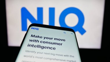 Stuttgart, Almanya - 10-11-2025: Araştırma şirketi Nielsen Consumer LLLC 'nin (NIQ) web sitesiyle birlikte logo önünde cep telefonu. Telefon ekranının sol üst kısmına odaklan.