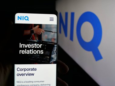 Stuttgart, Almanya - 10-11-2025: Araştırma şirketi Nielsen Consumer LLLC 'nin (NIQ) web sayfası olan cep telefonu logosu önünde ekranda. Telefon ekranının merkezine odaklan.
