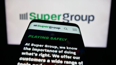 Stuttgart, Almanya - 10-11-2025: Spor bahisleri şirketi Super Group 'un web sitesi logonun önünde ekranda. Telefon ekranının sol üst kısmına odaklan.