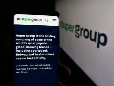 Stuttgart, Almanya - 10-11-2025: Spor bahisleri şirketi Super Group 'un web sayfası olan cep telefonu logonun önünde ekranda. Telefon ekranının merkezine odaklan.