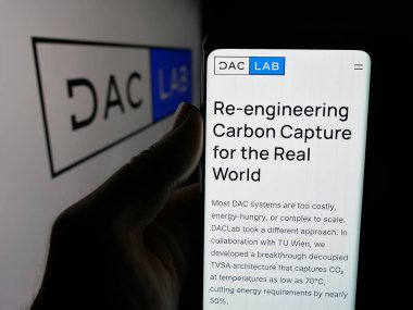 Stuttgart, Almanya - 10-11-2025: ABD 'li karbon temizleme şirketi DACLab' ın web sayfası olan akıllı telefon sahibi kişi logonun önünde ekranda. Telefon ekranının merkezine odaklan.