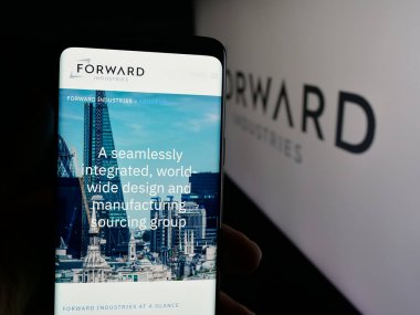 Stuttgart, Almanya - 10-11-2025: ABD 'li tasarım şirketi Forward Industries Inc.' in web sayfası olan cep telefonu logonun önünde ekranda. Telefon ekranının merkezine odaklan.