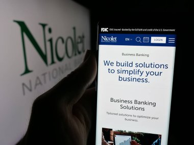 Stuttgart, Almanya - 10-11-2025: ABD 'li finans hizmetleri şirketi Nicolet Bank' ın web sayfası ile akıllı telefon sahibi kişi logonun önünde ekranda. Telefon ekranının merkezine odaklan.