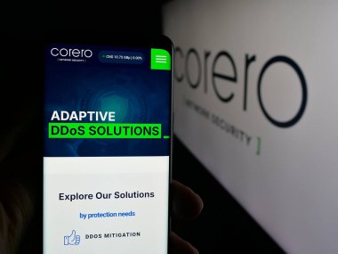 Stuttgart, Almanya - 10-11-2025: Corero Network Security şirketinin internet sayfası ile logo önünde cep telefonu tutan kişi. Telefon ekranının merkezine odaklan.