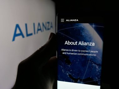 Stuttgart, Almanya - 10-11-2025: İletişim yazılım şirketi Alianza Inc. 'in web sayfası ile akıllı telefonu olan kişi logonun önünde ekranda. Telefon ekranının merkezine odaklan.