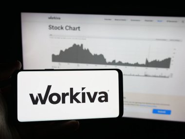 Stuttgart, Almanya - 10-12-2025: Web sitesinin önünde ekranda ABD 'li uyumluluk yazılım şirketi Workiva Inc.' in logosuna sahip akıllı telefonu tutan kişi. Telefon ekranına odaklan.