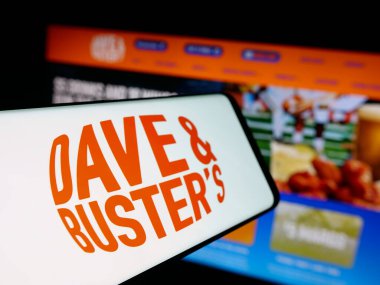 Stuttgart, Almanya - 10-13-2025: Dave and Buster 's Entertainment Inc. şirketinin logosuna sahip akıllı telefon web sitesinin önünde ekranda. Telefon ekranının merkez soluna odaklan.