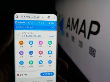 Stuttgart, Almanya - 10-13-2025: Çin çevrimiçi harita servisi AMap 'in web sayfası ile akıllı telefonu olan kişi logonun önünde ekranda. Telefon ekranının merkezine odaklan.