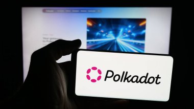 Stuttgart, Almanya - 10-13-2025: Web sayfası önünde ekranda engelleme şirketi Polkadot 'nun logosu olan cep telefonu sahibi kişi. Telefon ekranına odaklan.