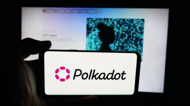 Stuttgart, Almanya - 10-13-2025: Web sayfası önünde ekranda engelleme şirketi Polkadot 'nun logosu olan cep telefonu sahibi kişi. Telefon ekranına odaklan.