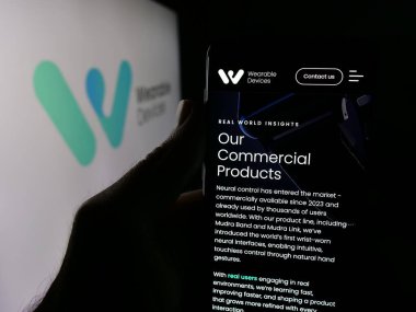 Stuttgart, Almanya - 10-13-2025: Logonun önündeki ekranda nöral teknoloji şirketinin web sayfası bulunan akıllı telefon sahibi kişi. Telefon ekranının merkezine odaklan.