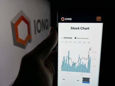 Stuttgart, Almanya - 10-13-2025: ABD 'li kuantum bilgisayar şirketi IonQ Inc.' in web sayfası ile akıllı telefonu olan kişi logonun önünde ekranda. Telefon ekranının merkezine odaklan.
