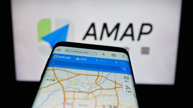 Stuttgart, Almanya - 10-13-2025: Çin çevrimiçi harita servis şirketi AMap 'in web sitesiyle birlikte cep telefonu logonun önünde ekranda. Telefon ekranının sol üst kısmına odaklan.