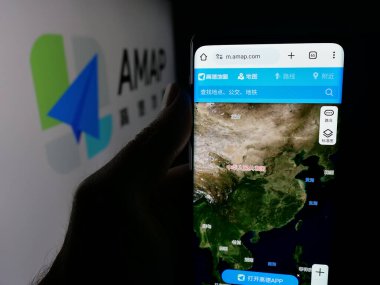 Stuttgart, Almanya - 10-13-2025: Çin çevrimiçi harita servisi AMap 'in internet sayfası olan cep telefonu logosu önünde ekranda. Telefon ekranının merkezine odaklan.
