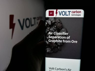 Stuttgart, Almanya - 10-13-2025: Kanadalı Volt Carbon Technologies Inc. 'in web sayfası ile logo önünde cep telefonu tutan kişi. Telefon ekranının merkezine odaklan.