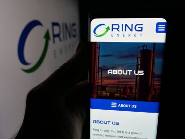 Stuttgart, Almanya - 10-13-2025: ABD 'li petrol ve doğalgaz şirketi Ring Energy Inc.' in web sayfası ile akıllı telefon sahibi kişi logonun önünde ekranda. Telefon ekranının merkezine odaklan.