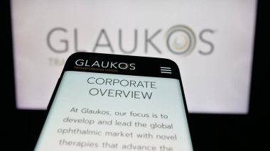 Stuttgart, Almanya - 10-13-2025: ABD 'li oftalmik şirket Glaukos Corporation' ın web sitesi ile birlikte logo önünde cep telefonu. Telefon ekranının sol üst kısmına odaklan.