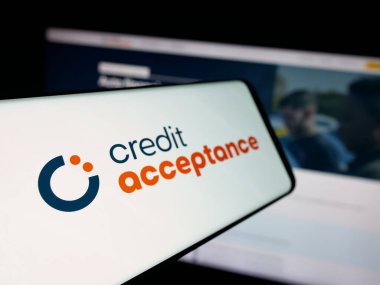 Stuttgart, Almanya - 10-13-2025: Otomobil finans şirketi Credit Acceptance Corp 'un logosuna sahip akıllı telefon web sitesinin önünde ekranda. Telefon ekranının soluna odaklan.