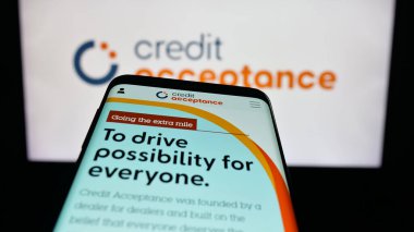 Stuttgart, Almanya - 10-13-2025: Otomobil finans şirketi Credit Acceptance Corp. 'un web sitesi bulunan cep telefonu logonun önünde ekranda. Telefon ekranının sol üst kısmına odaklan.