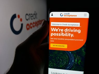 Stuttgart, Almanya - 10-13-2025: Otomobil finans şirketi Credit Acceptance Corp 'un web sayfası olan cep telefonu logonun önünde ekranda. Telefon ekranının merkezine odaklan.