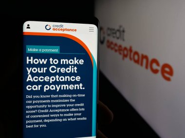 Stuttgart, Almanya - 10-13-2025: Otomobil finans şirketi Credit Acceptance Corp 'un web sayfasını elinde tutan kişi logonun önünde ekranda. Telefon ekranının merkezine odaklan.