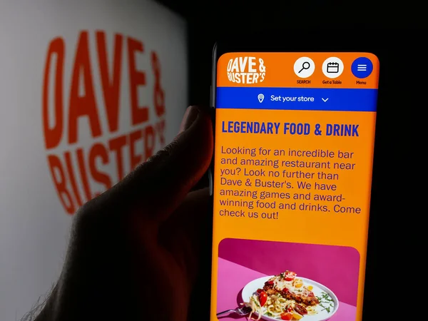 Stuttgart, Almanya - 10-13-2025: Dave and Buster 's Entertainment Inc. şirketinin web sayfası olan cep telefonu logonun önünde ekranda. Telefon ekranının merkezine odaklan.