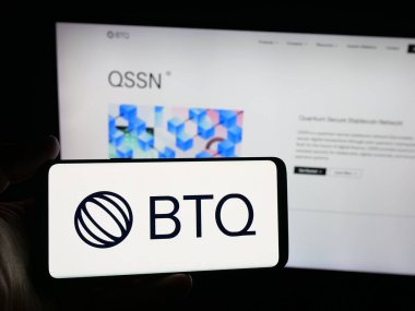 Stuttgart, Almanya - 10-15-2025: Üzerinde kuantum teknoloji şirketi BTQ Technologies Corp 'un logosu olan akıllı telefonu web sitesinin önünde ekranda tutan kişi. Telefon ekranına odaklan.