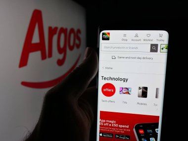 Stuttgart, Almanya - 10-15-2025: İngiliz perakende şirketi Argos Limited 'in internet sayfası olan cep telefonu logosu önünde ekranda. Telefon ekranının merkezine odaklan.