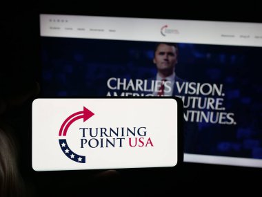 Stuttgart, Almanya - 10-15-2025: ABD 'nin Turning Point USA (TPUSA) organizasyonunun logosunun bulunduğu akıllı telefonu web sitesi önünde tutan kişi. Telefon ekranına odaklan.