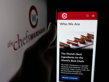 Stuttgart, Almanya - 10-16-2025: ABD 'li gıda şirketi The Chefs Warehouse Inc.' in web sayfası ile akıllı telefon tutan kişi logonun önünde ekranda. Telefon ekranının merkezine odaklan.