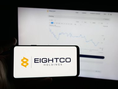 Stuttgart, Almanya - 10-16-2025: ABD 'li teknoloji şirketi Eightco Holding Inc.' in logosunu elinde tutan kişi web sitesinin önünde ekranda. Telefon ekranına odaklan.