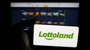 Stuttgart, Almanya - 10-17-2025: İnternetteki piyango şirketi Lottoland Limited 'in logosunun bulunduğu cep telefonu web sitesinin önünde. Telefon ekranına odaklan.