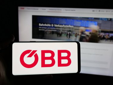 Stuttgart, Almanya - 10-17-2025: Demiryolu şirketi Oesterreichische Bundesbahnen 'in logosunu taşıyan kişi web sitesinin önünde ekranda. Telefon ekranına odaklan.