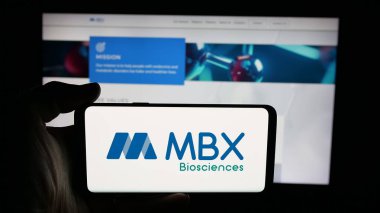 Stuttgart, Almanya - 10-18-2025: ABD 'li biyofizik şirketi MBX Biyobilim Şirketi logosu olan cep telefonu web sayfası önünde ekranda. Telefon ekranına odaklan.