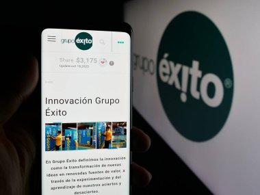 Stuttgart, Almanya - 10-18-2025: Kolombiyalı perakende şirketi Grupo Exito 'nun web sayfası olan akıllı telefon sahibi kişi logonun önünde ekranda. Telefon ekranının merkezine odaklan.