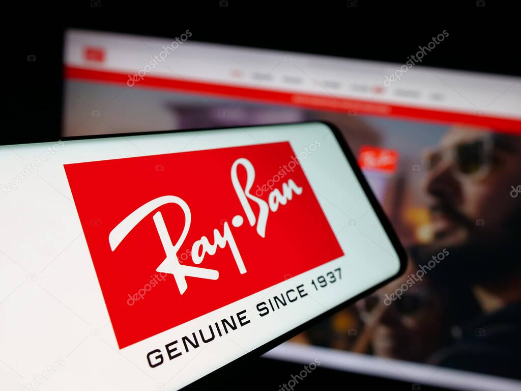Stuttgart, Germany - 10-16-2025: Smartphone with logo of luxury eyewear company Ray-Ban on screen in front of website. Focus on center-left of phone display.