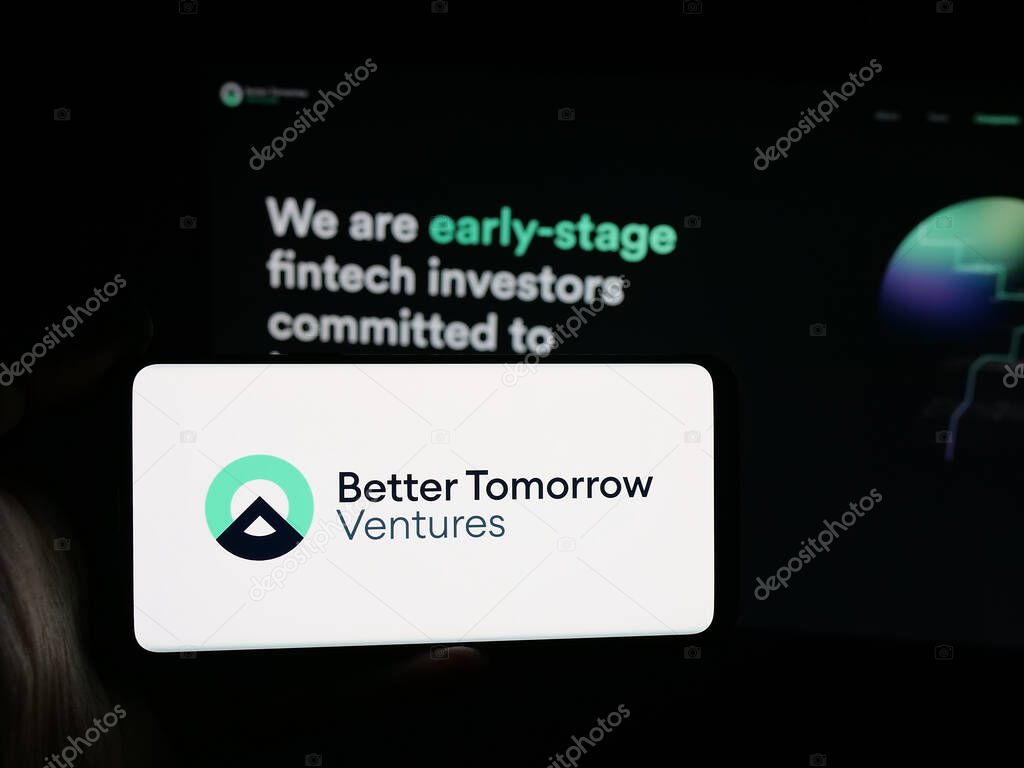 Stuttgart, Germany - 10-18-2025: Person holding smartphone with logo of US company Better Tomorrow Ventures (BTV) on screen in front of website. Focus on phone display.