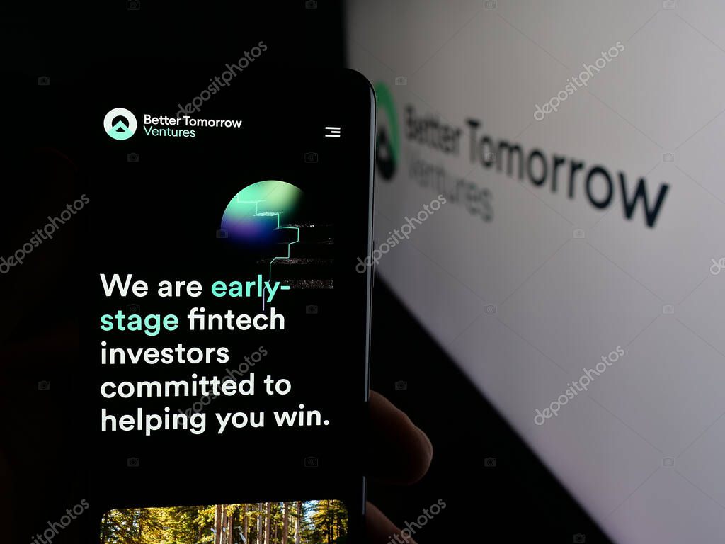 Stuttgart, Germany - 10-18-2025: Person holding cellphone with webpage of US company Better Tomorrow Ventures (BTV) on screen in front of logo. Focus on center of phone display.