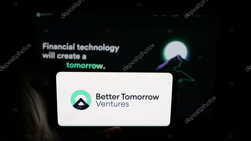 Stuttgart, Germany - 10-18-2025: Person holding cellphone with logo of US company Better Tomorrow Ventures (BTV) on screen in front of webpage. Focus on phone display.