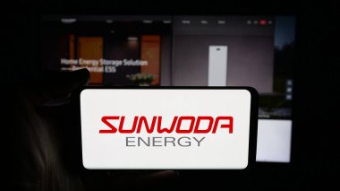 Stuttgart, Almanya - 10-19-2025: Sunwoda Enerji Teknolojisi Şirketi logosu olan cep telefonu sahibi kişi web sayfasının önünde ekranda. Telefon ekranına odaklan.