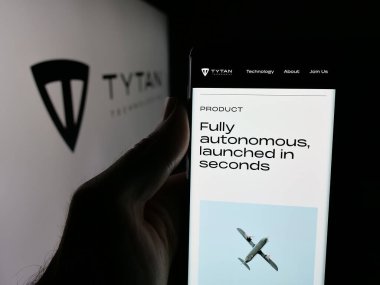 Stuttgart, Almanya - 10-19-2025: Savunma şirketi TYTAN Technologies GmbH 'nin web sayfası ile akıllı telefonu olan kişi logonun önünde ekranda. Telefon ekranının merkezine odaklan.