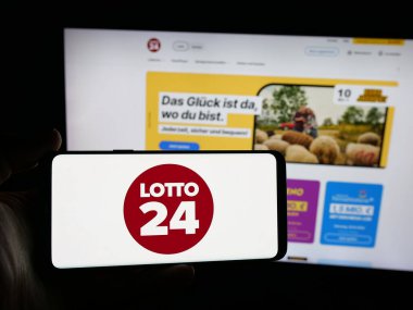 Stuttgart, Almanya - 10-19-2025: İnternet sitesinin önündeki ekranda Alman piyango şirketi Lotto24 AG 'nin logosunu taşıyan kişi. Telefon ekranına odaklan.