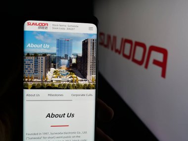 Stuttgart, Almanya - 10-19-2025: Çinli şirket Sunwoda Electronic Co. Ltd. nin internet sayfası ile cep telefonu tutan kişi logonun önünde ekranda. Telefon ekranının merkezine odaklan.