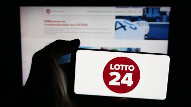 Stuttgart, Almanya - 10-19-2025: İnternet sayfasının önünde Alman piyango şirketi Lotto24 AG 'nin logosu olan cep telefonu sahibi kişi. Telefon ekranına odaklan.