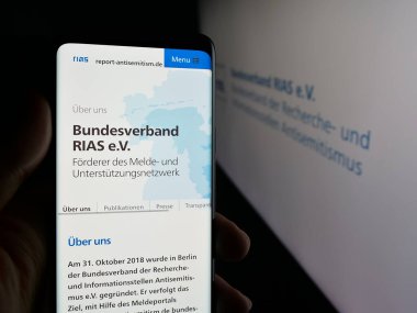 Stuttgart, Almanya - 10-20-2025: Alman Bundesverband RIAS E.V. web sitesi ile cep telefonu tutan kişi Ekranda logonun önünde. Telefon ekranının merkezine odaklan.
