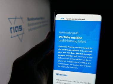 Stuttgart, Almanya - 10-20-2025: Alman Bundesverband RIAS E.V. web sitesi ile akıllı telefon tutan kişi Ekranda logonun önünde. Telefon ekranının merkezine odaklan.