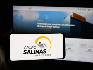 Stuttgart, Almanya - 10-20-2025: İnternet sitesinin önünde Meksika holdingi Grupo Salinas 'ın logosuna sahip akıllı telefonu elinde tutan kişi. Telefon ekranına odaklan.