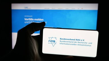 Stuttgart, Almanya - 10-20-2025: Alman Bundesverband RIAS E.V. logosu taşıyan kişi Web sayfasının önünde ekranda. Telefon ekranına odaklan.